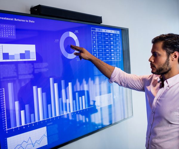 Businessman analyzing data with a touch screen in office